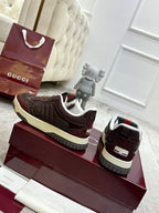 Gucci unisex sneakers set on display, dark brown leather with striped heel trim