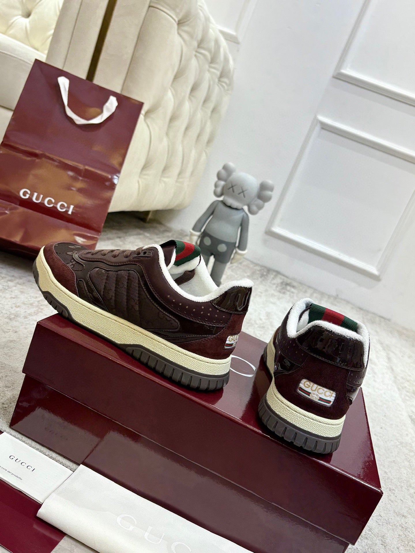 Brown lace-up sneaker with green-red web detail on tongue and cream sole