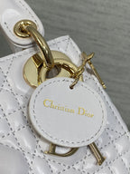 Dior bag charm and clasp close-up with gold hardware and circular logo tag