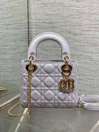 Dior quilted mini bag, front view, with top handles, gold rings, and chain strap