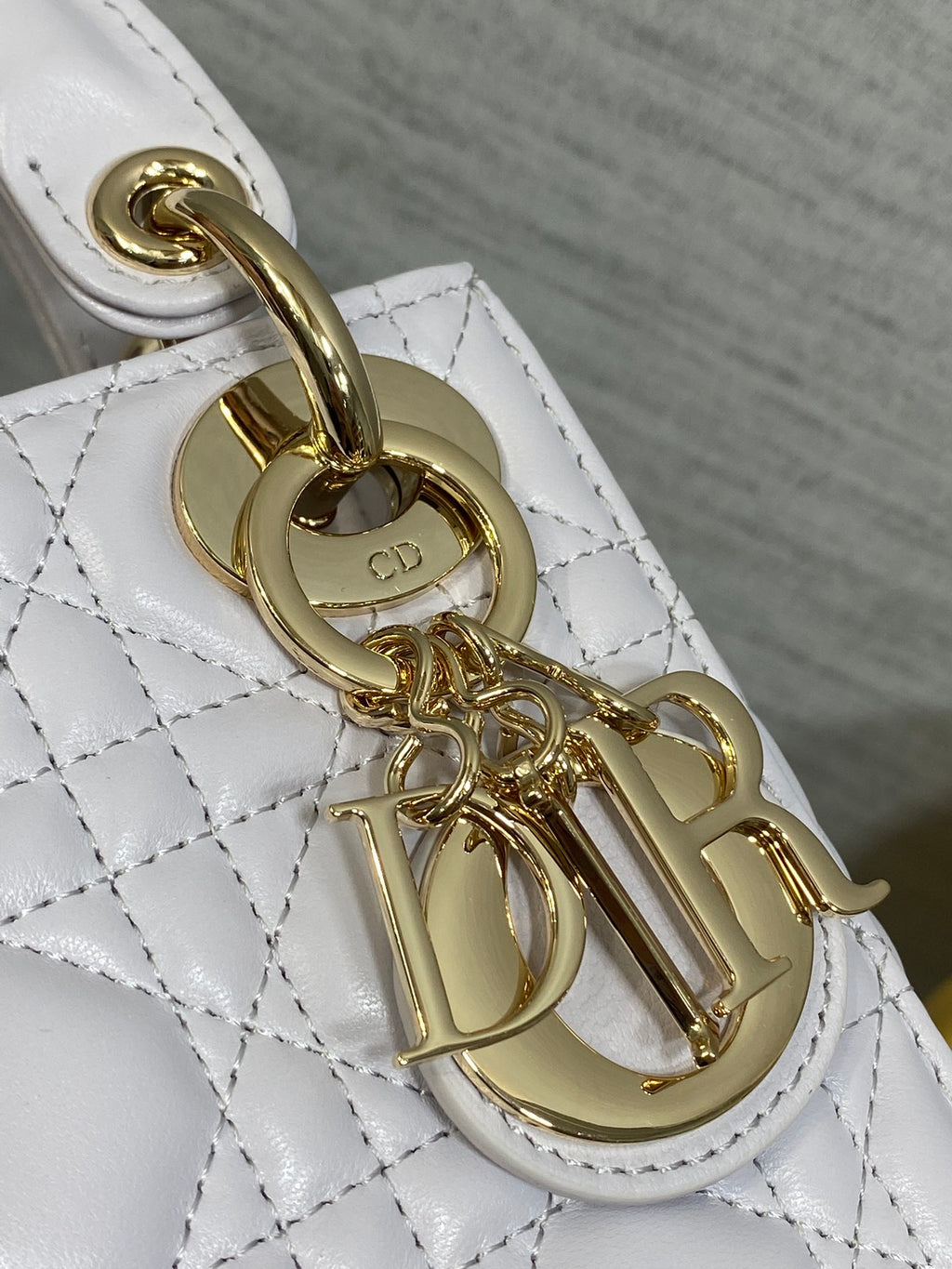Dior bag hardware close-up with gold clasp and chain attachment on quilted leather