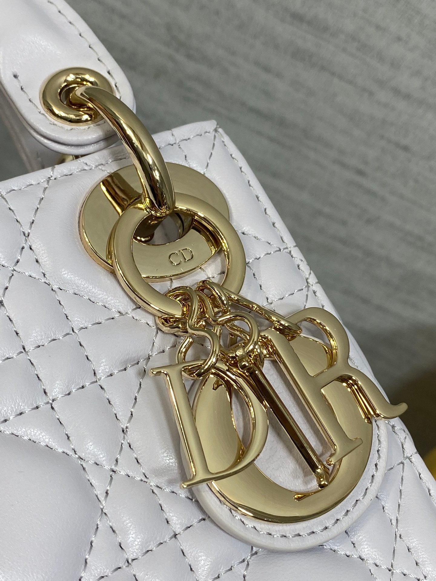 Dior bag hardware close-up with gold clasp and chain attachment on quilted leather