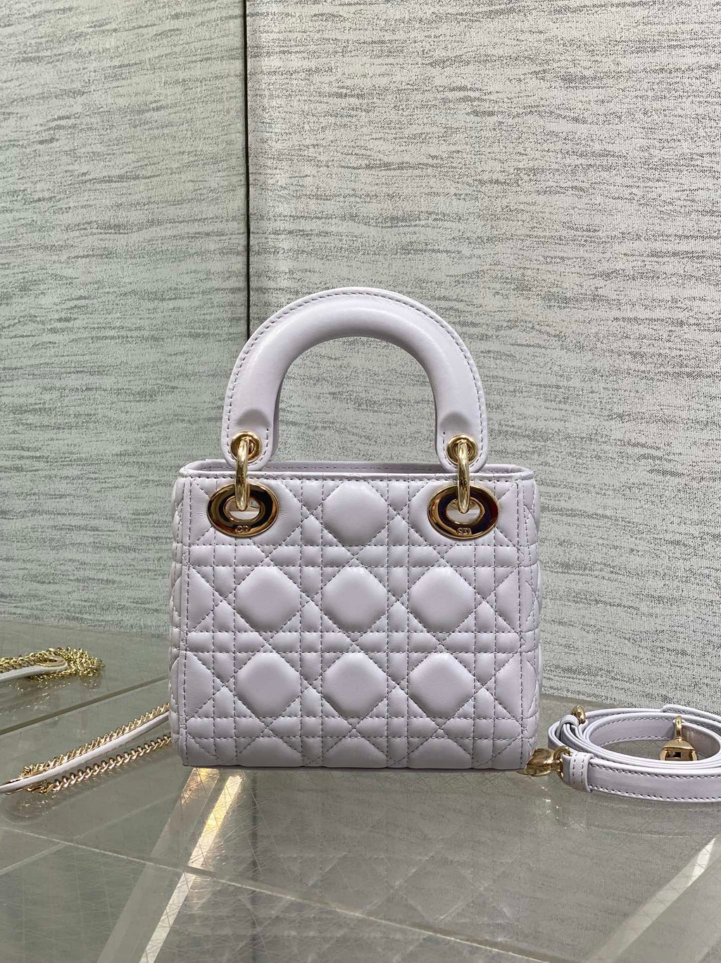 Dior quilted mini bag with top handles and gold hardware, plus detachable chain strap