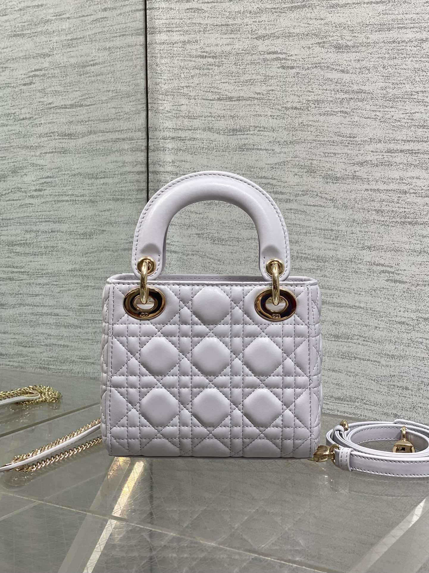 Dior quilted mini bag with top handles and gold hardware, plus detachable chain strap