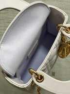 Dior mini bag interior view with light lining and gold clasp near the opening