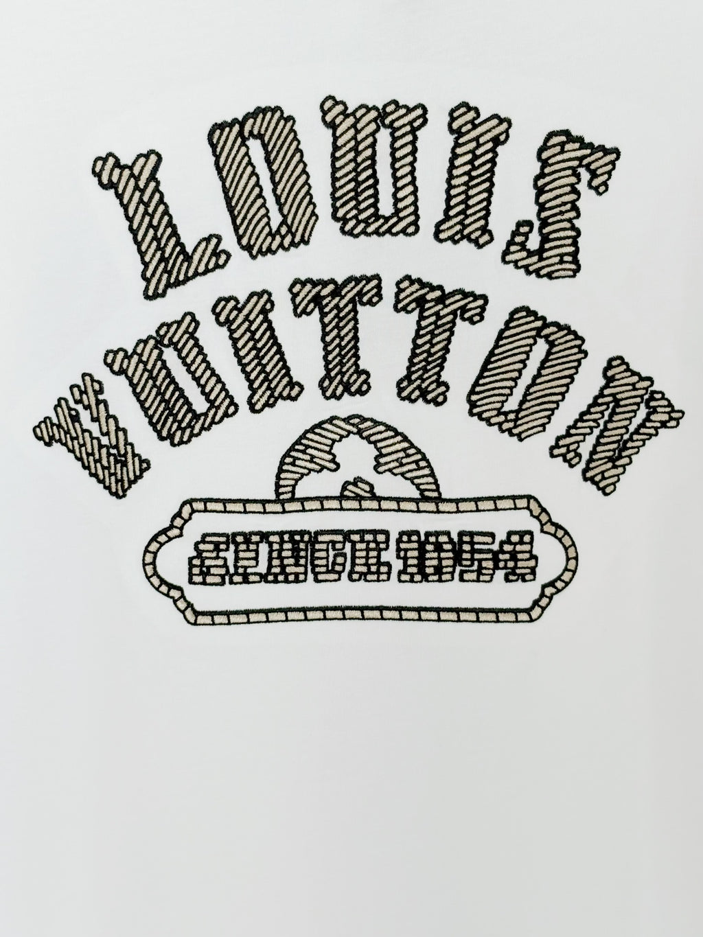 White Louis Vuitton T-shirt close-up of embroidered text and emblem graphic
