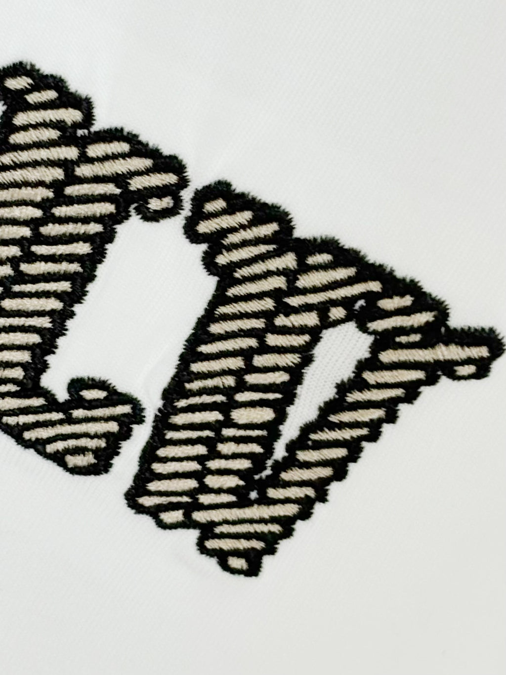 White Louis Vuitton T-shirt close-up of embroidered LV lettering detail