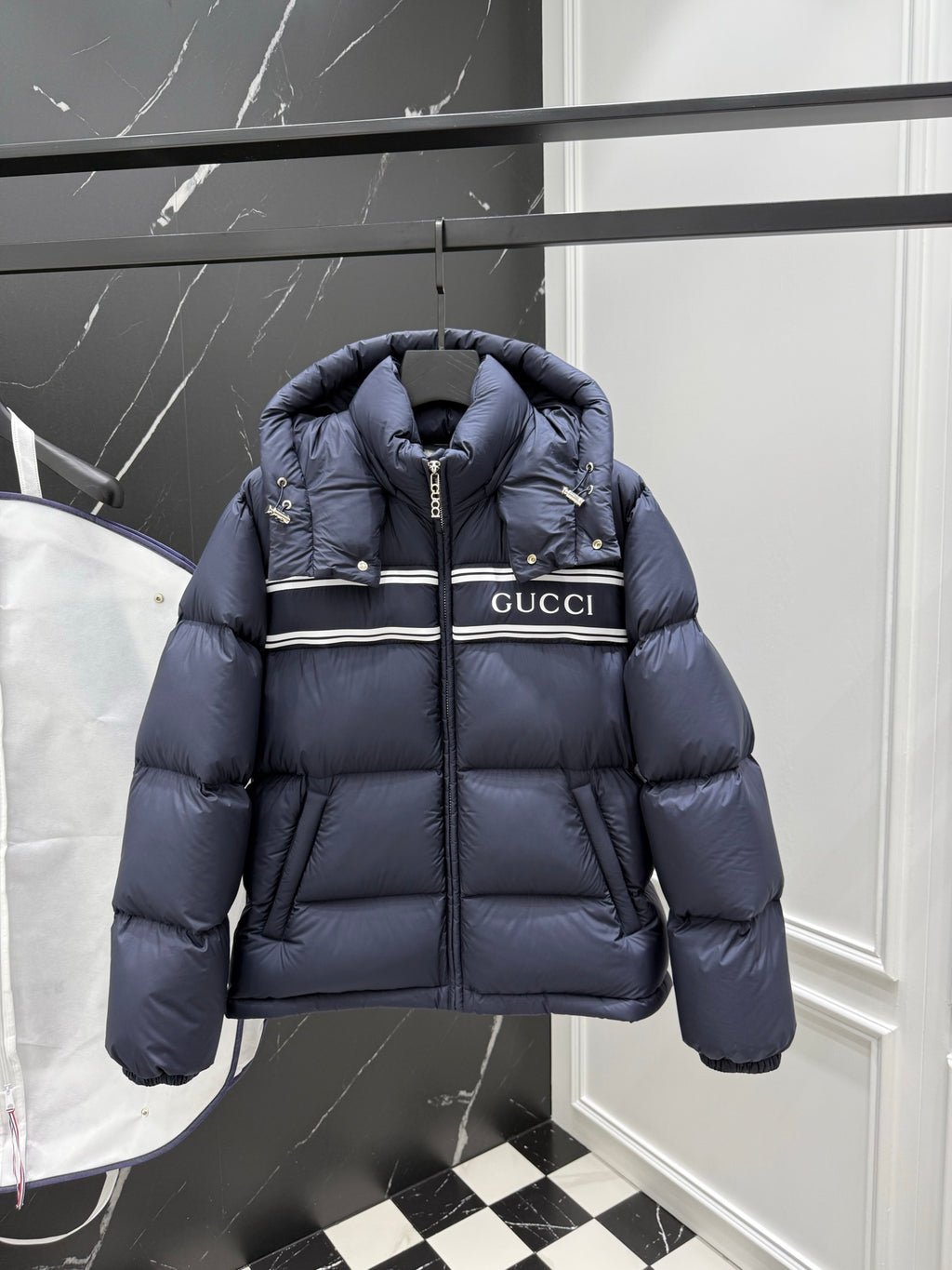 Dark blue hooded puffer jacket with front zipper and Gucci logo stripe