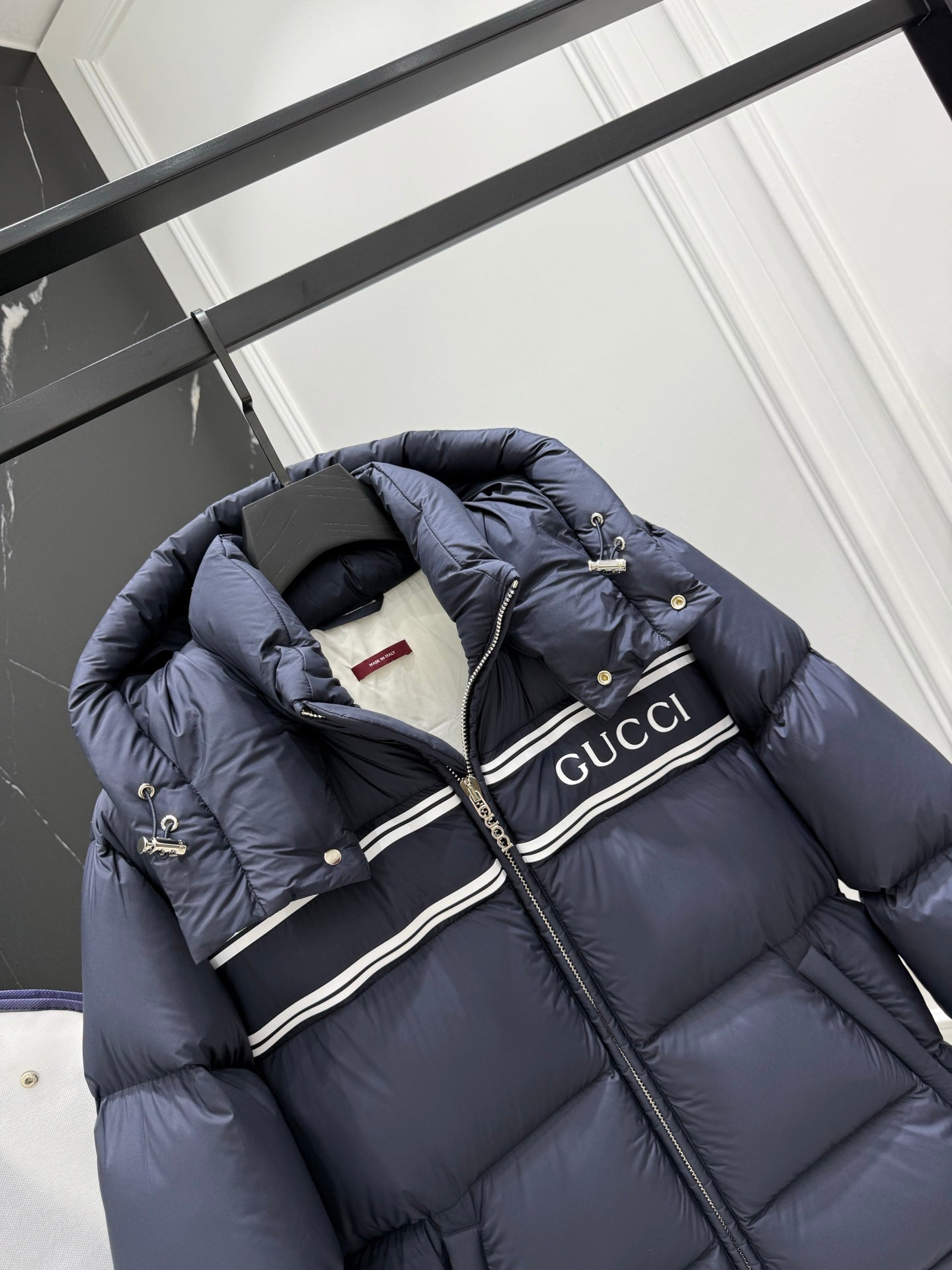Dark blue hooded puffer jacket with striped Gucci logo panel and front zipper