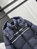 Dark blue hooded puffer jacket with striped Gucci logo band and snap buttons