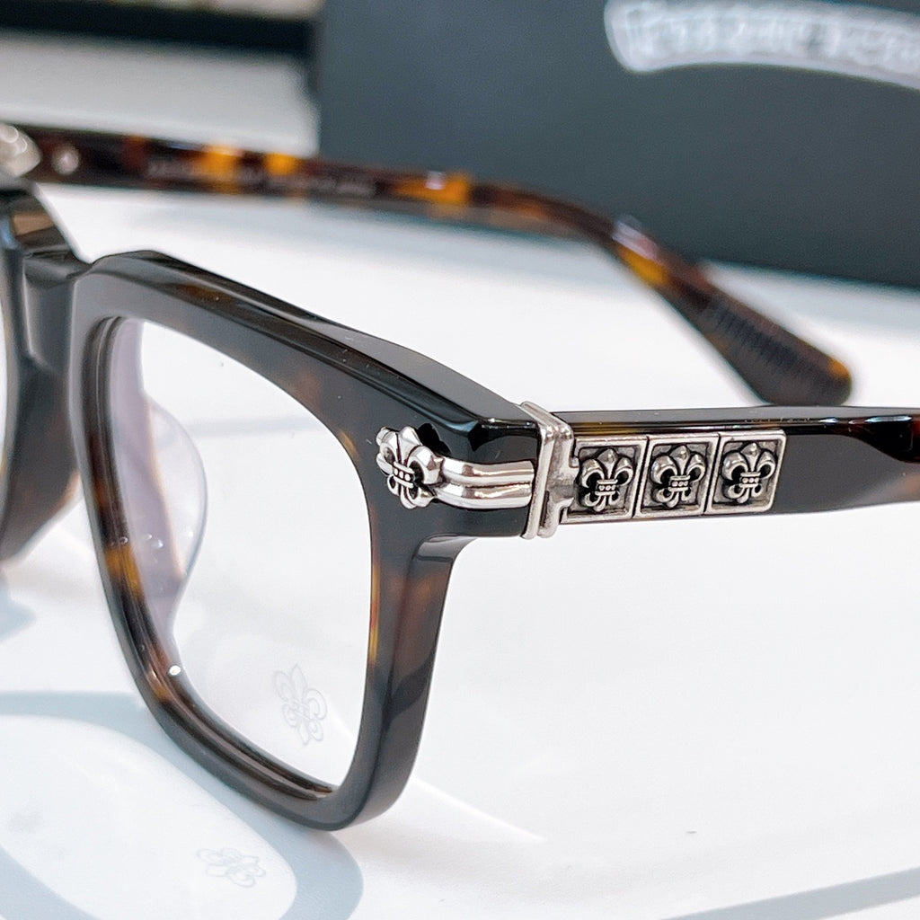 Black eyeglasses with ornate silver-tone hinge bar on temple