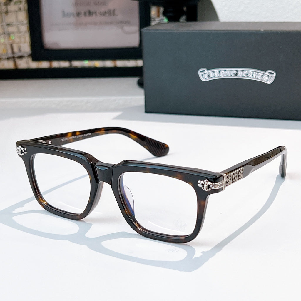Black eyeglasses with gold-tone studded hinge bar and patterned top bridge