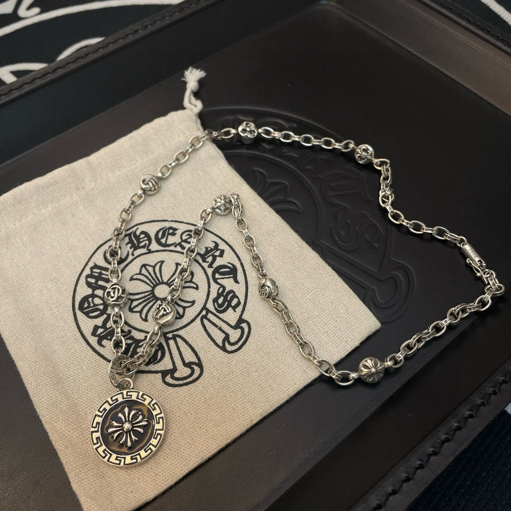 Silver-tone pendant necklace with round sun medallion on a pouch display