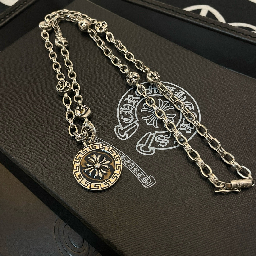Silver-tone pendant necklace with round sun medallion and curved charm detail