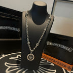 Silver-tone pendant necklace featuring a round sunburst medallion on a linked chain