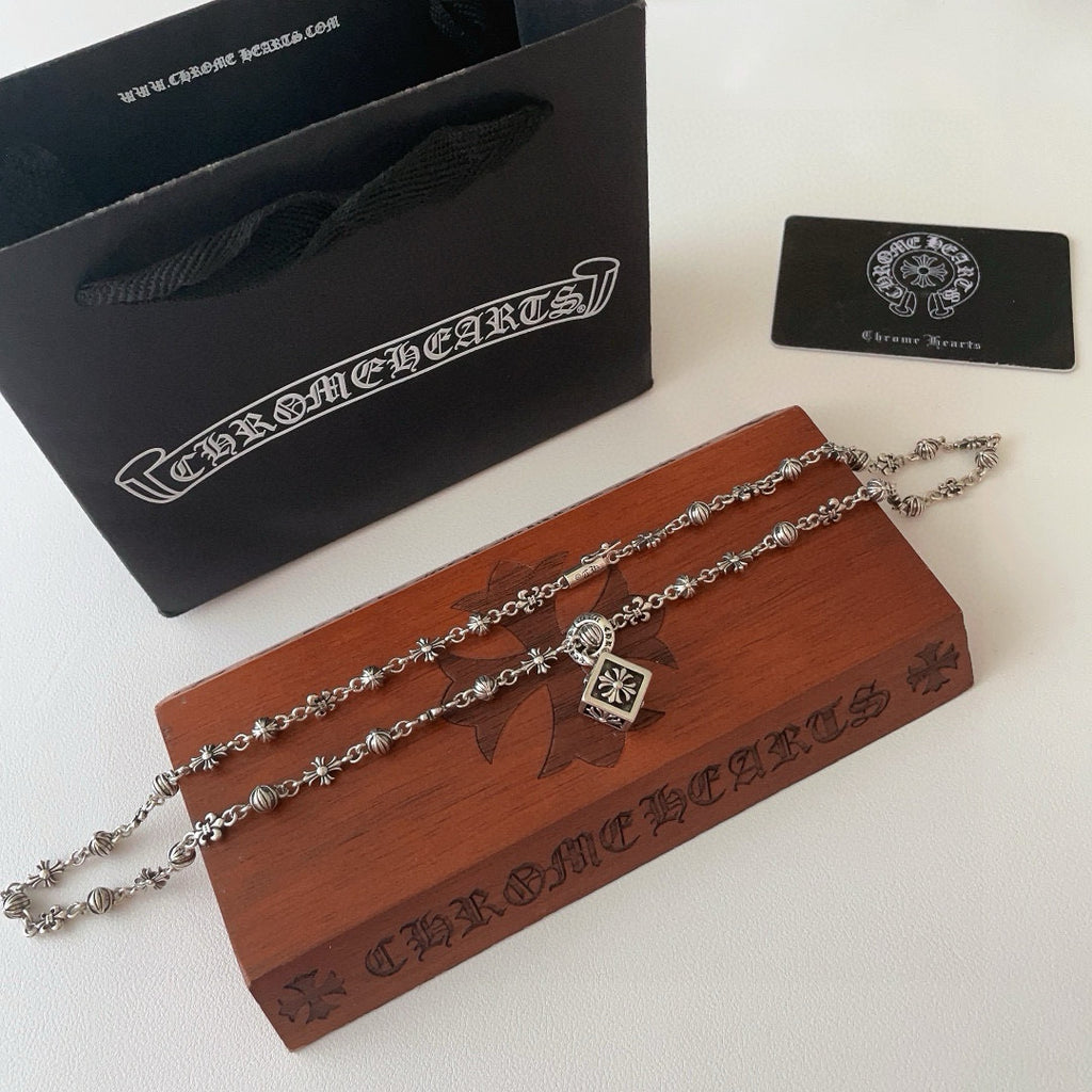 Silver-tone charm necklace with square flower pendant and small floral charm stations