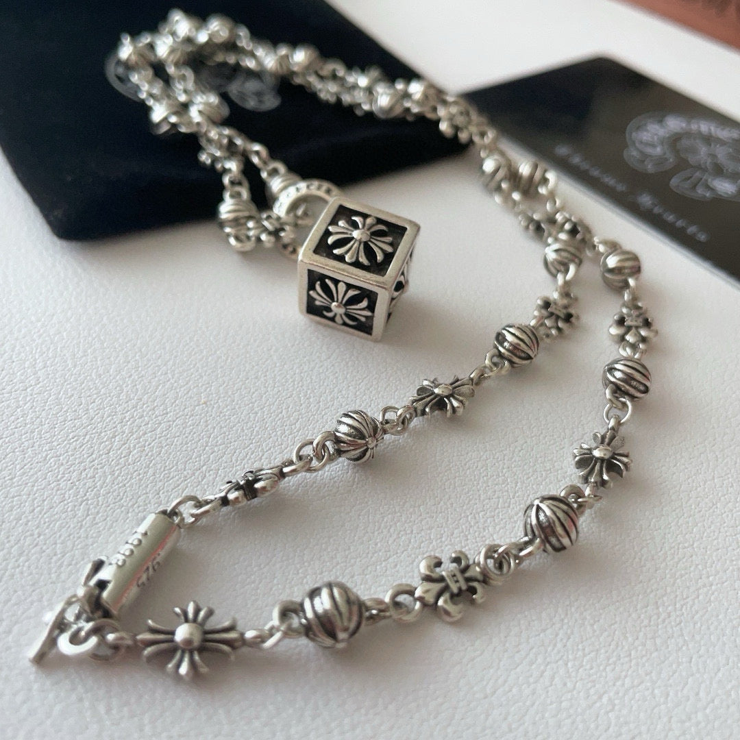 Silver-tone charm necklace with square flower pendant and floral bead segments