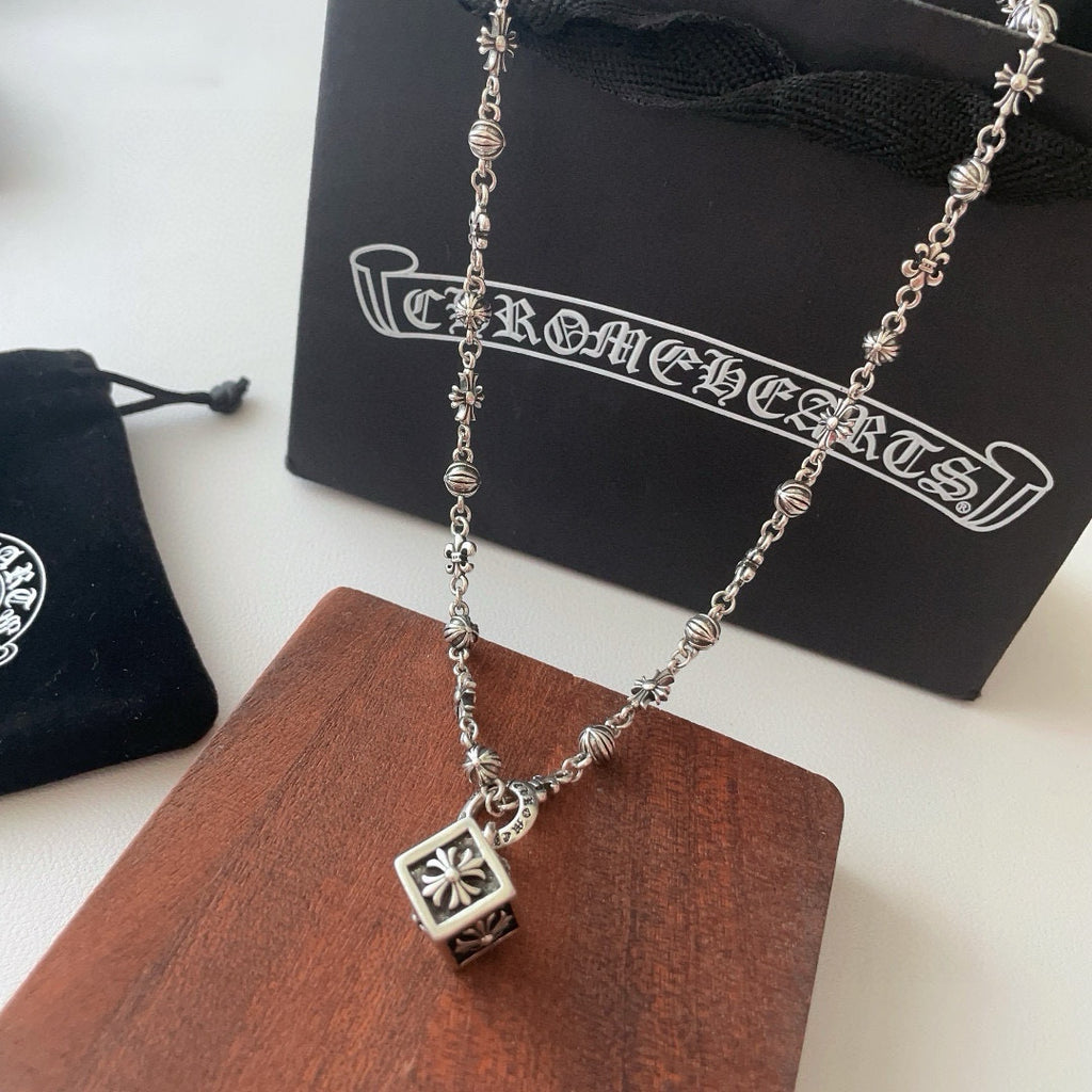 Silver-tone charm necklace with square flower pendant and small cross-like accents