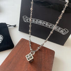 Silver-tone charm necklace with square flower pendant and small cross-like accents