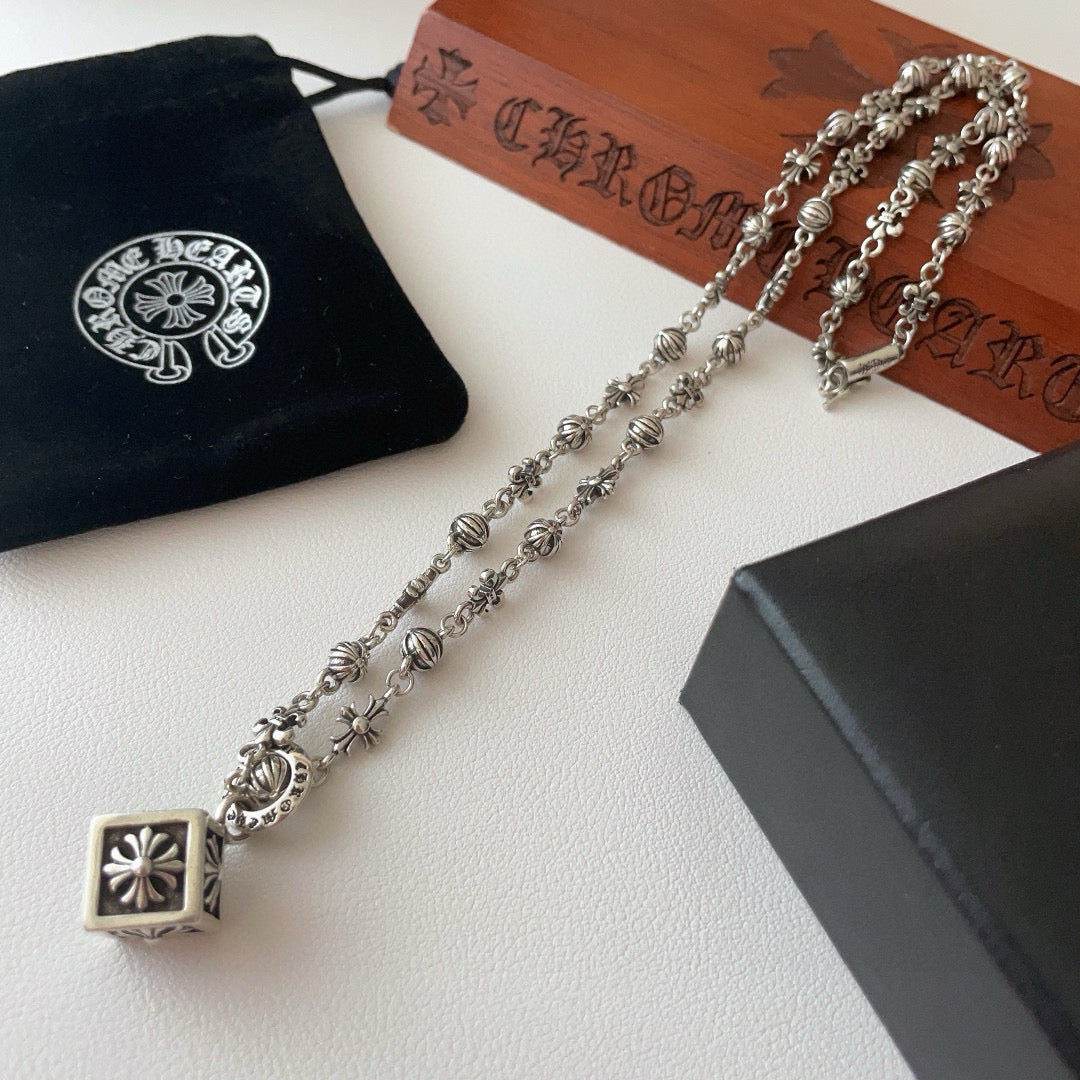 Silver-tone charm necklace with square flower pendant and chain links with bead accents