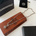 Silver-tone charm necklace with square flower pendant and layered chain styling