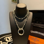 Silver chain necklace with circular ring pendant and long layered links on bust.