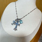 Silver cross pendant necklace with blue gemstones and detailed link chain