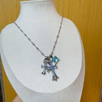 Silver cross pendant necklace with blue gemstone accents on a chain