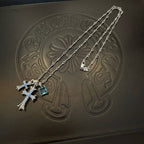 Silver cross pendant necklace with blue gemstones and long layered chain