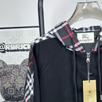 Dark navy zip jacket with plaid hood trim and a visible front zipper pull