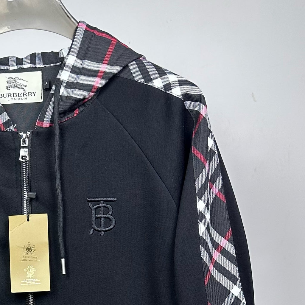 Side view of dark navy hooded zip jacket with plaid sleeve panel and logo