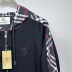 Side view of dark navy hooded zip jacket with plaid sleeve panel and logo