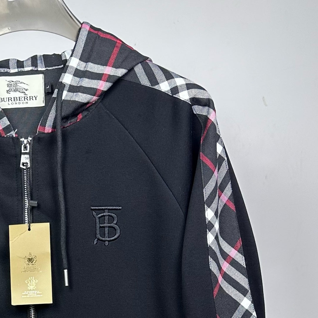 Side view of dark navy hooded zip jacket with plaid sleeve panel and logo