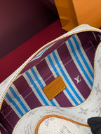 Louis Vuitton crossbody bag interior detail with white monogram lining and blue stripe panel