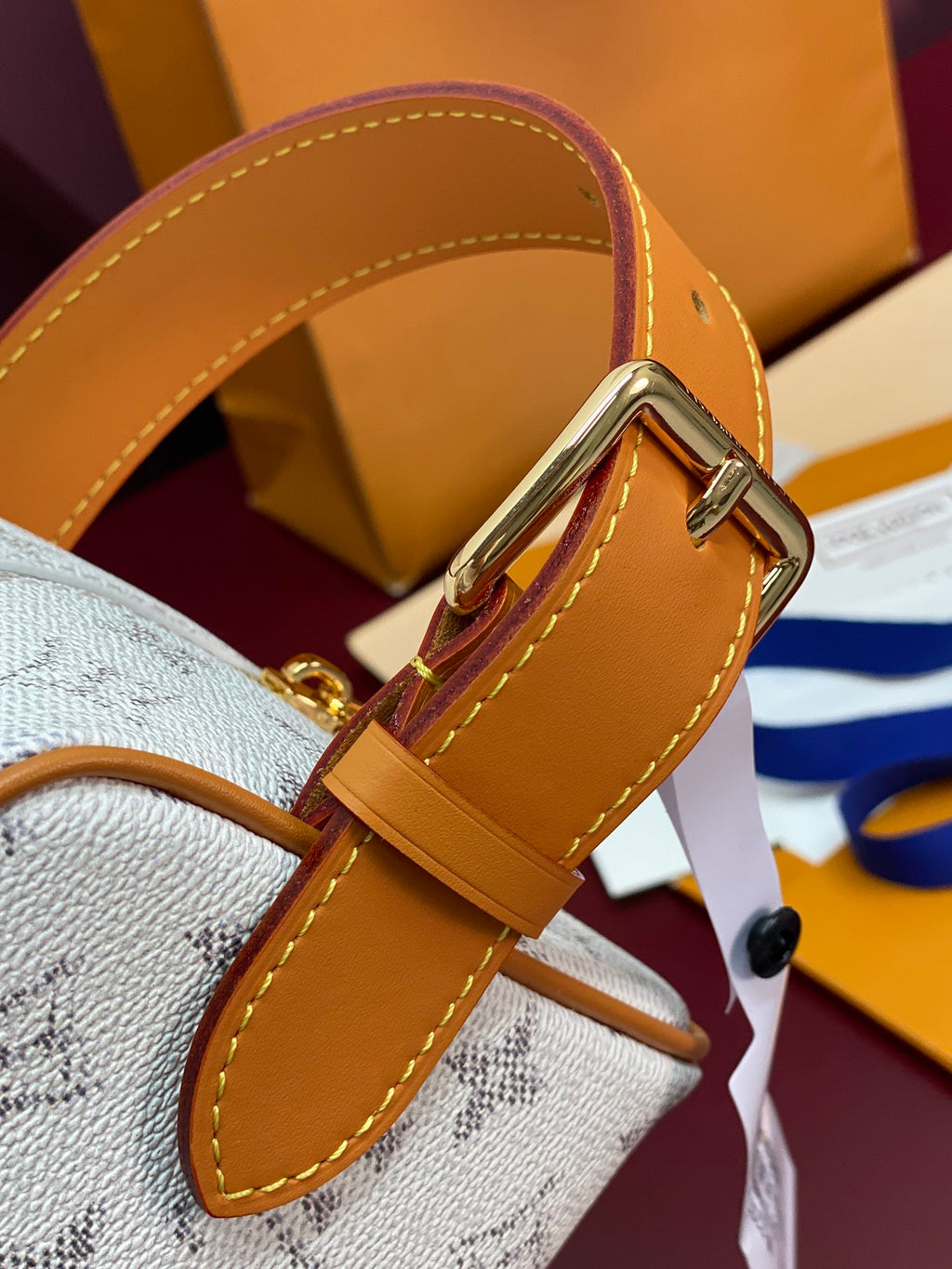 Louis Vuitton crossbody bag close-up of tan leather strap and gold metal hardware