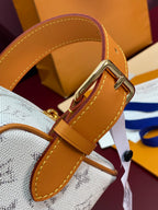 Louis Vuitton crossbody bag close-up of tan leather strap and gold metal hardware