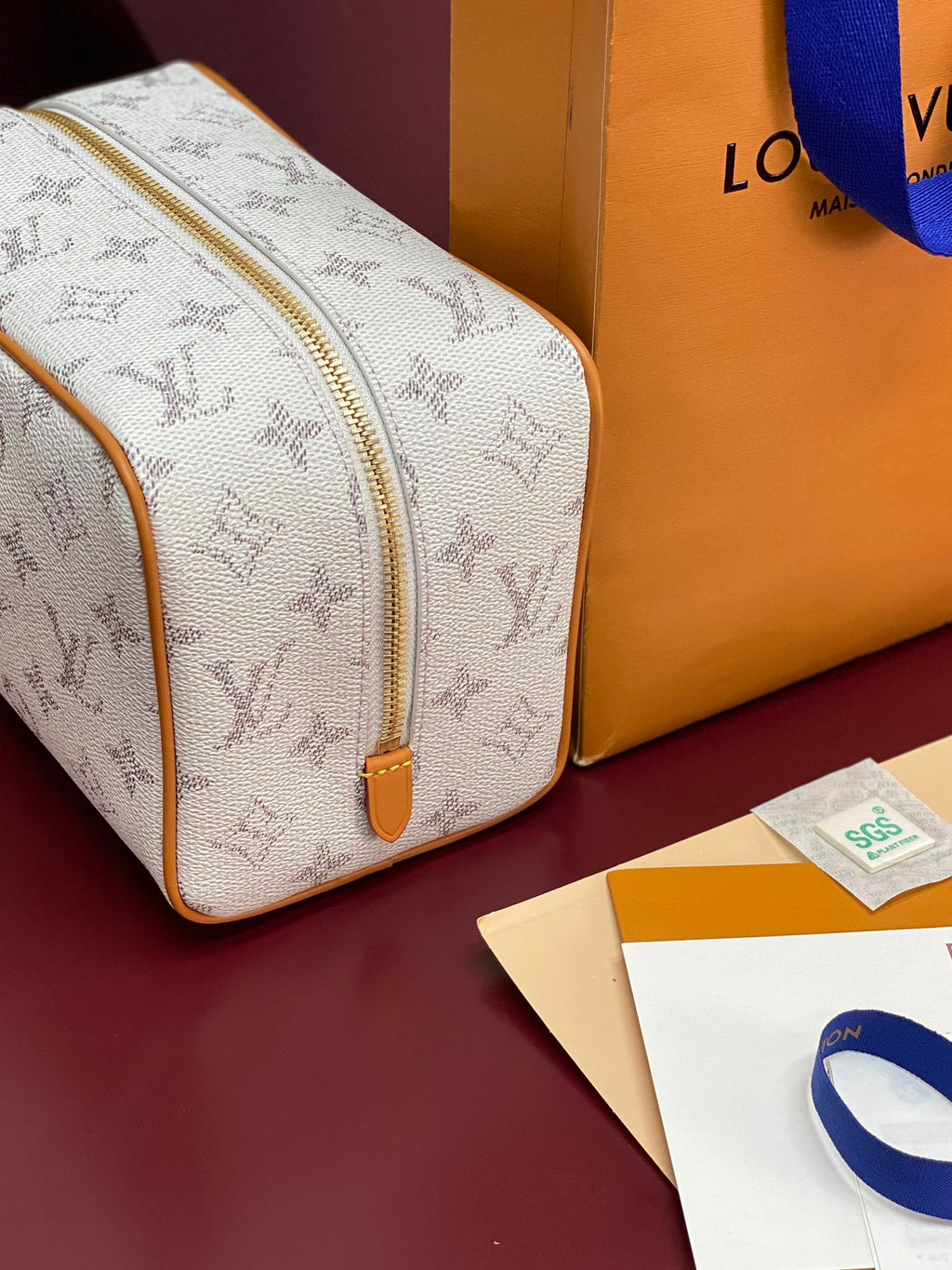Louis Vuitton crossbody bag close-up of white monogram canvas and tan zipper trim