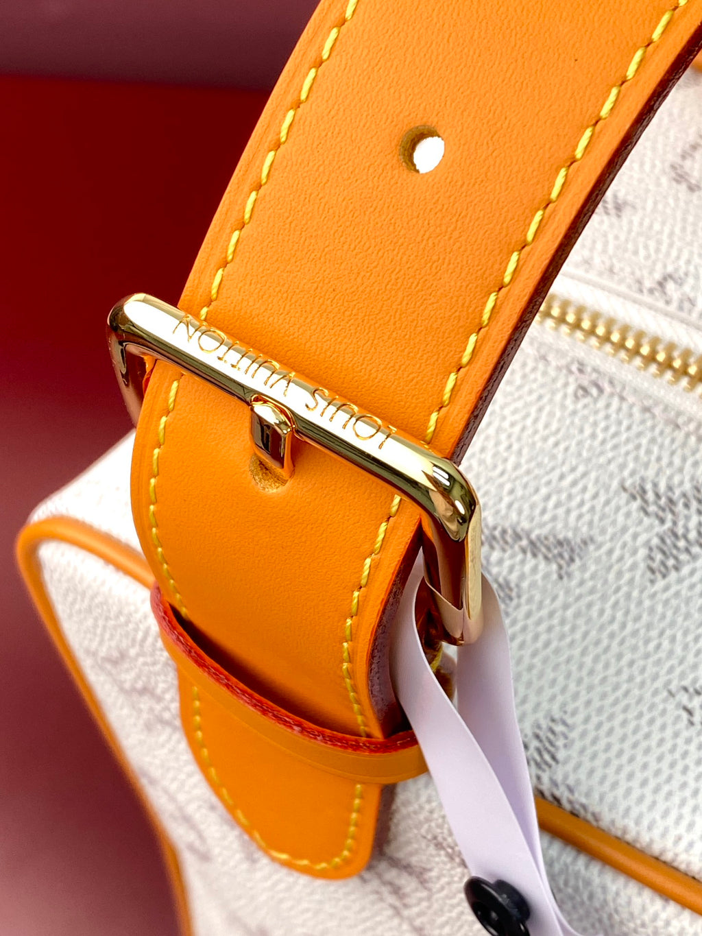 Louis Vuitton crossbody bag hardware detail on tan leather strap with gold clasp