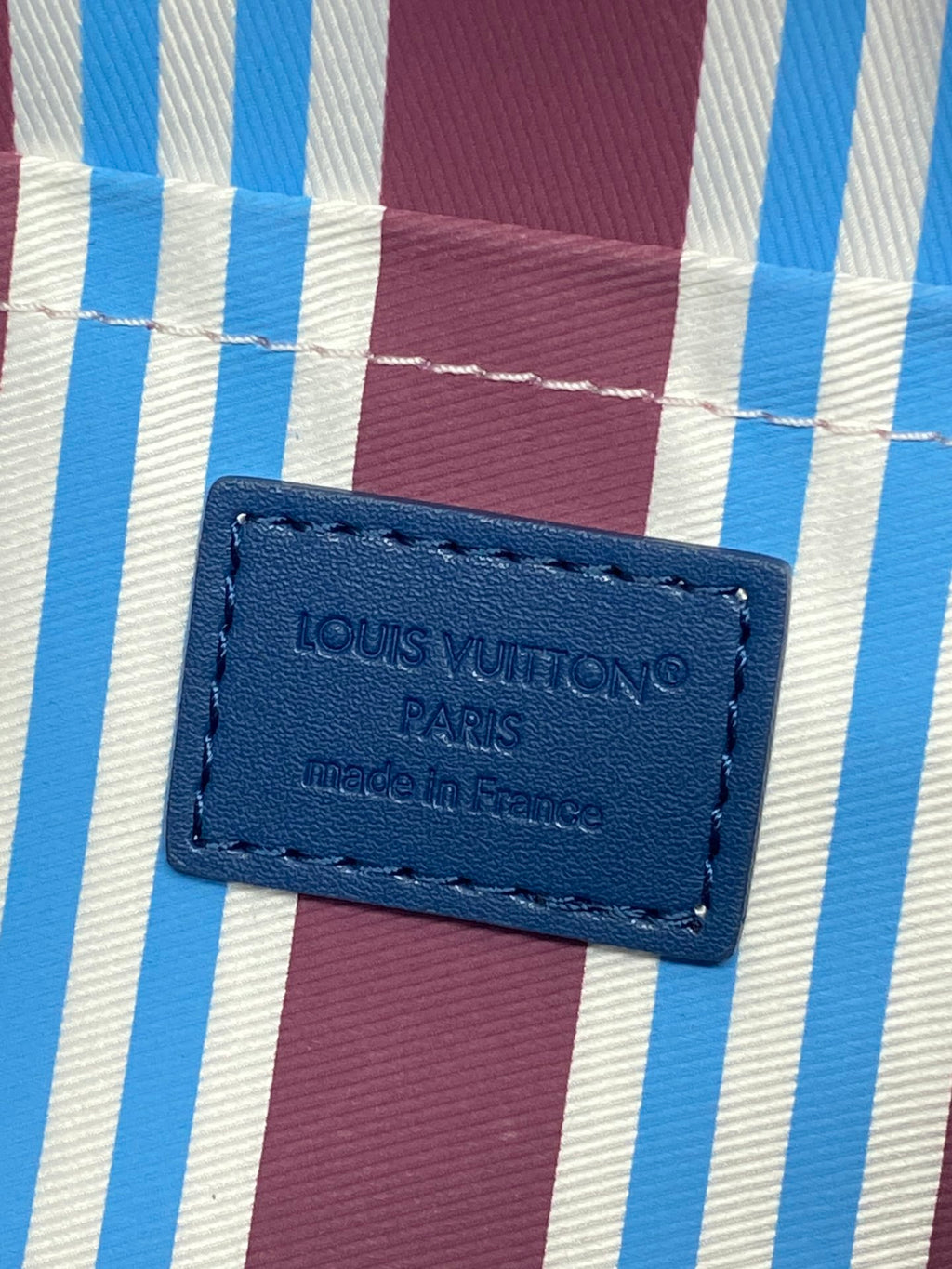 Louis Vuitton blue fabric label patch on a checkered bag lining