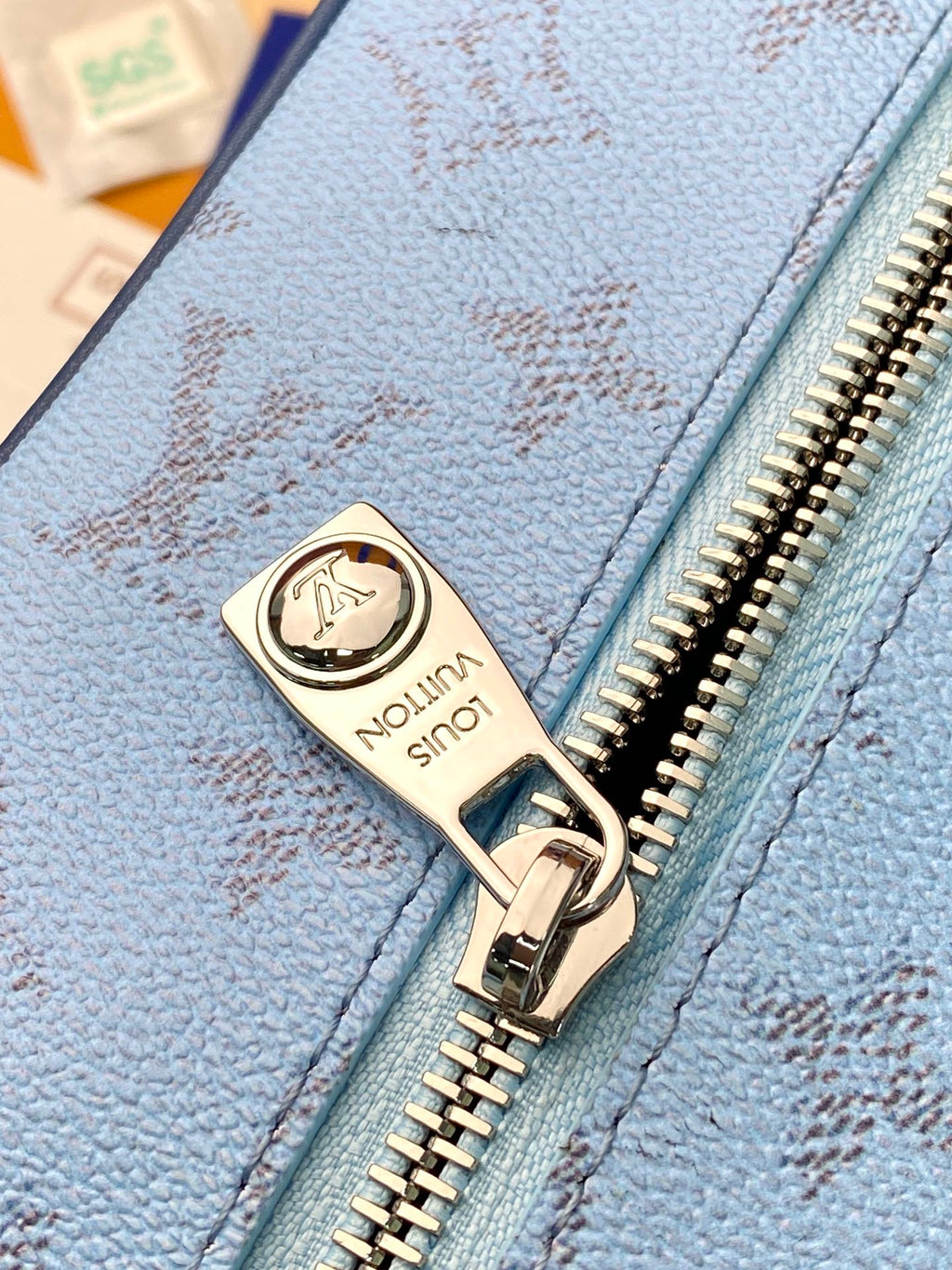 Louis Vuitton bag zipper detail with logo pull on blue textured leather