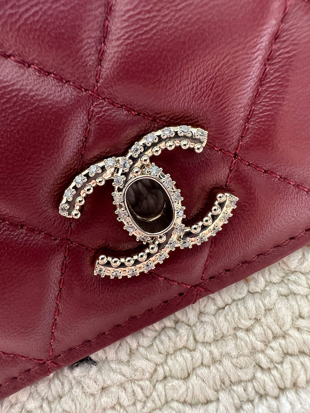 Burgundy quilted flap with Chanel logo and rhinestone button hardware