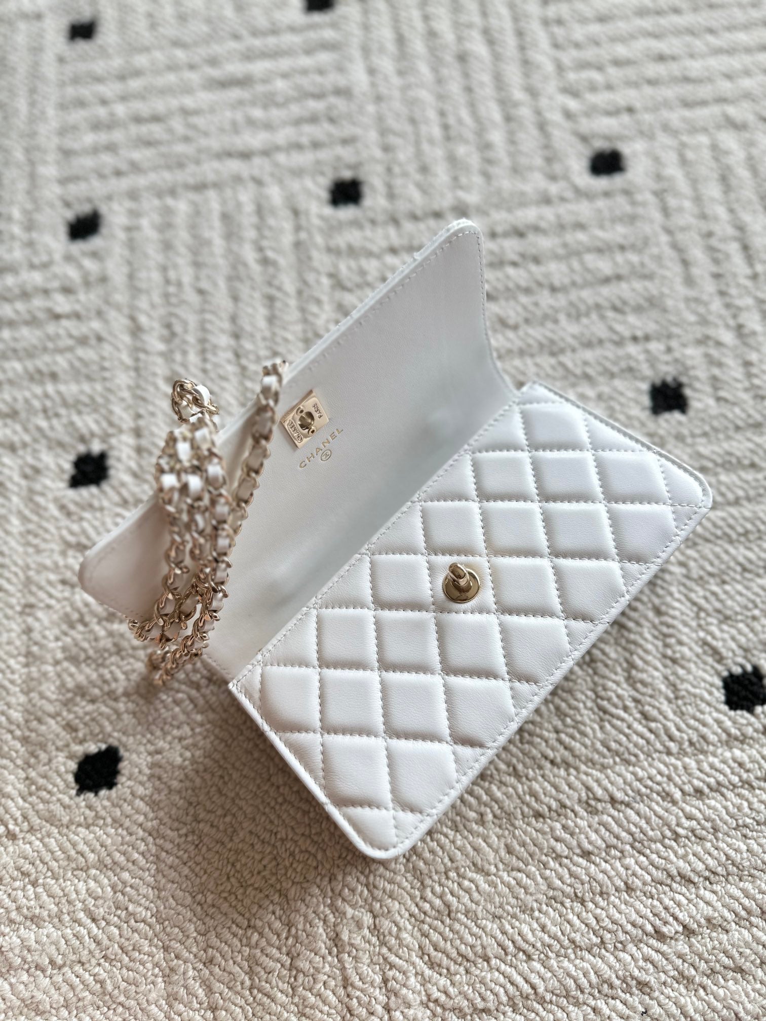 White quilted leather mini flap bag with chain strap and gold-tone hardware.