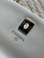 White leather flap bag with CHANEL logo metal turn-lock clasp.