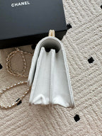 White quilted mini flap bag with open top and drawstring-like flap edges.