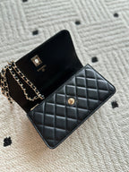Chanel black quilted flap bag with chain strap and gold button detail