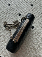 Chanel black quilted mini shoulder bag with chain strap and metal hardware close-up