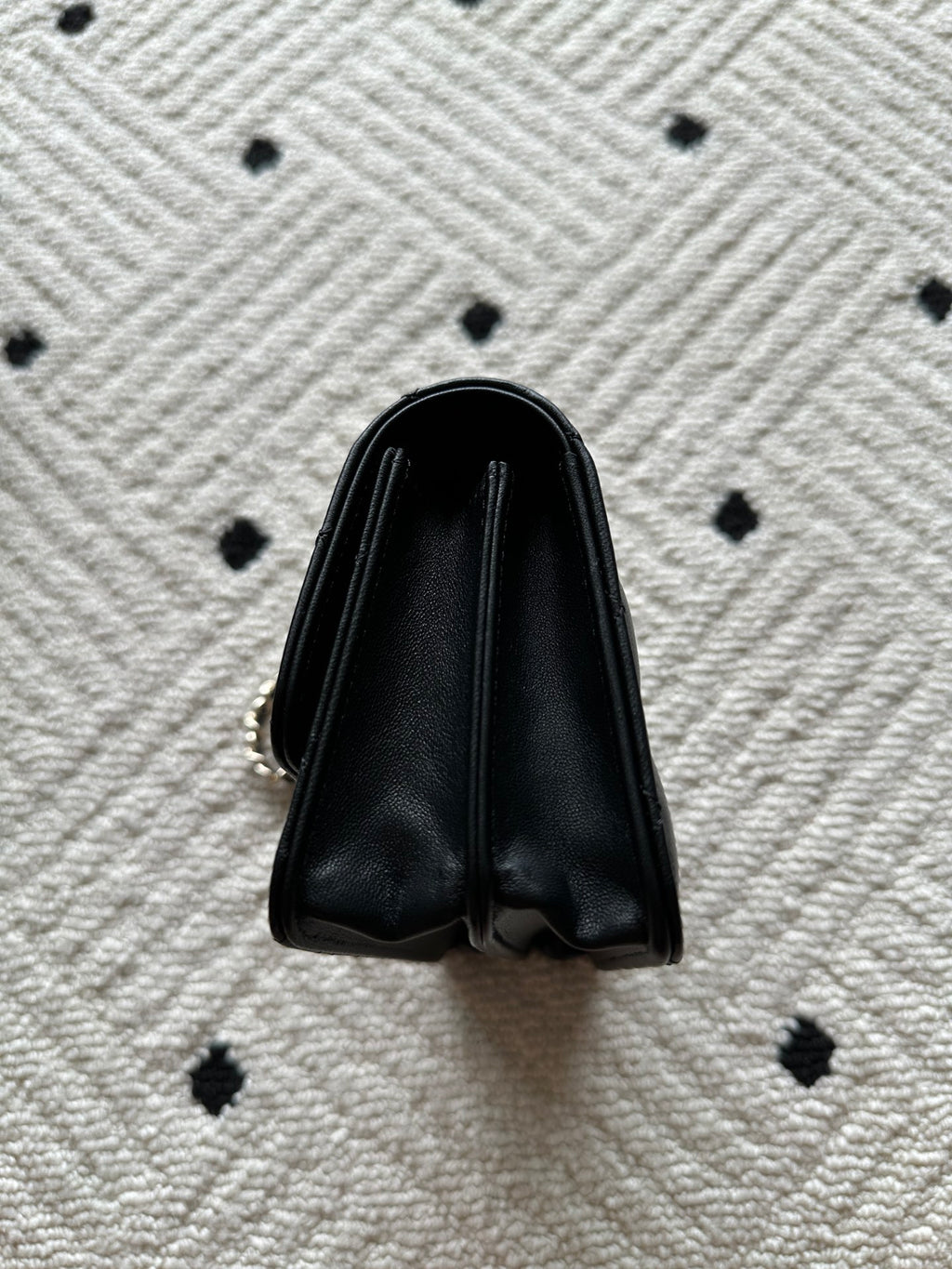 Chanel small black leather bag with curved top and metal chain attachment