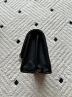Chanel small black leather bag with curved top and metal chain attachment