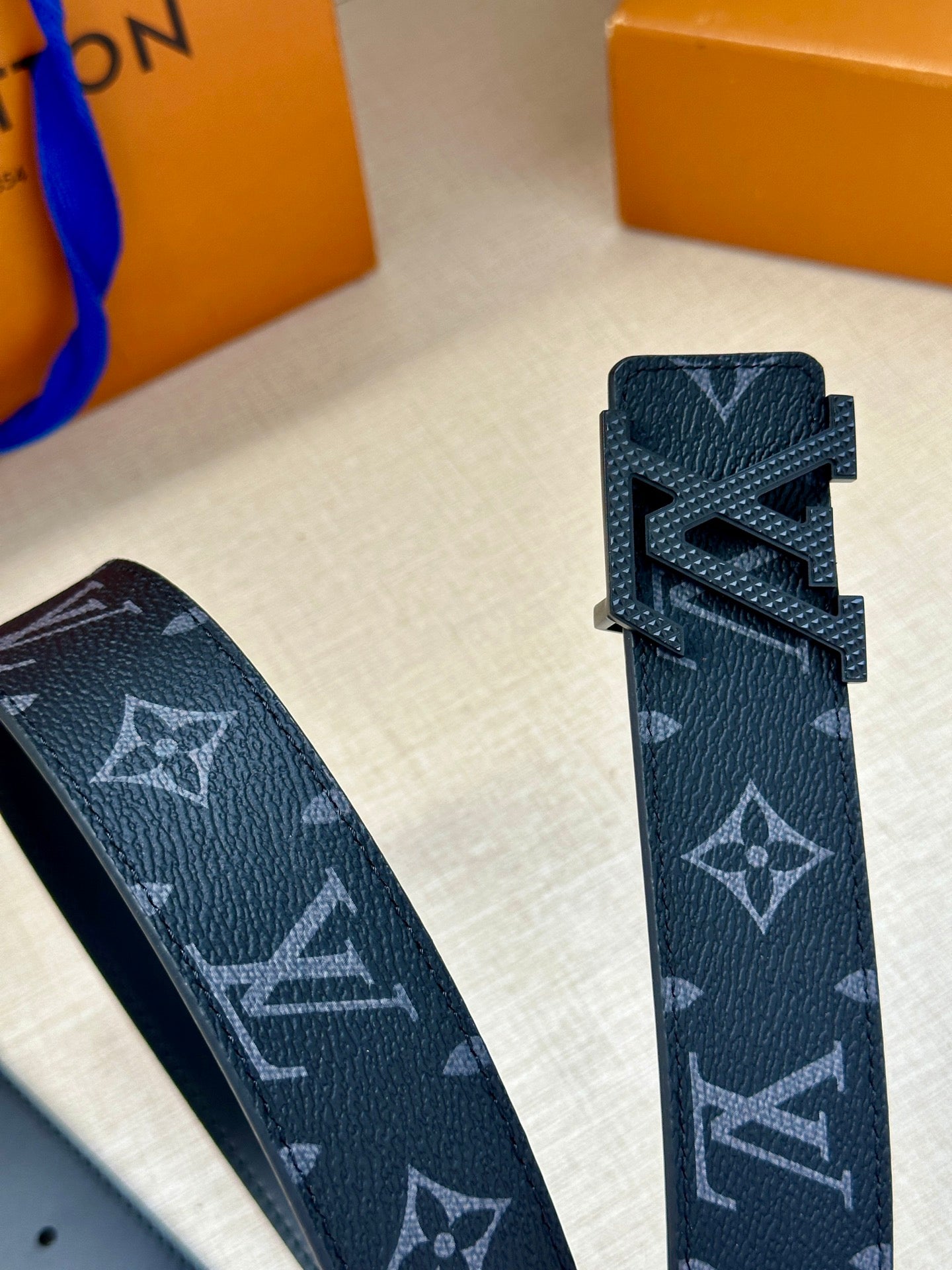Louis Vuitton belt strap end detail with dark navy monogram finish and cutout buckle area