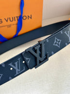 Louis Vuitton belt close-up: dark navy monogram strap with silver buckle and textured edge